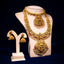 Gold necklace and earrings on a mannequin bust against a dark background
