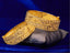Two gold bangles on a dark blue background