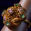 Gold ring with gemstones on a wrist against a dark background