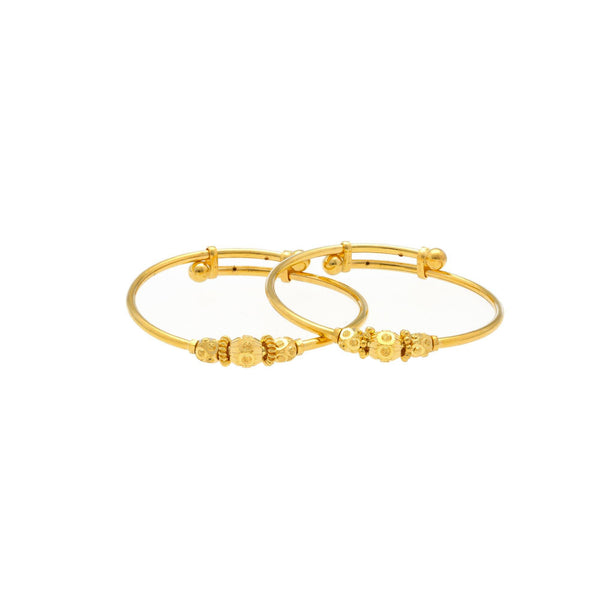 An image of two 22K gold bangles from Virani Jewelers overlapping each other. | Introduce your child to a world of elegance with this 22K gold baby bangle from Virani Jewelers!
...