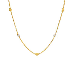 An image of a 22K gold necklace from Virani Jewelers with yellow and white gold beads spread throughout the wheat link chain.