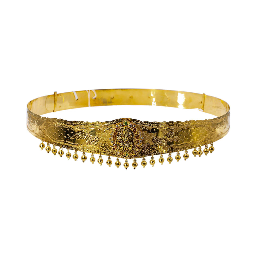 A picture of a 22K waist belt from Virani Jewelers featuring an image of Laxmi surrounded by gemstones and dangling gold balls. | Add movement and luxury to your most festive looks with Vaddanam waist belts that will transform ...